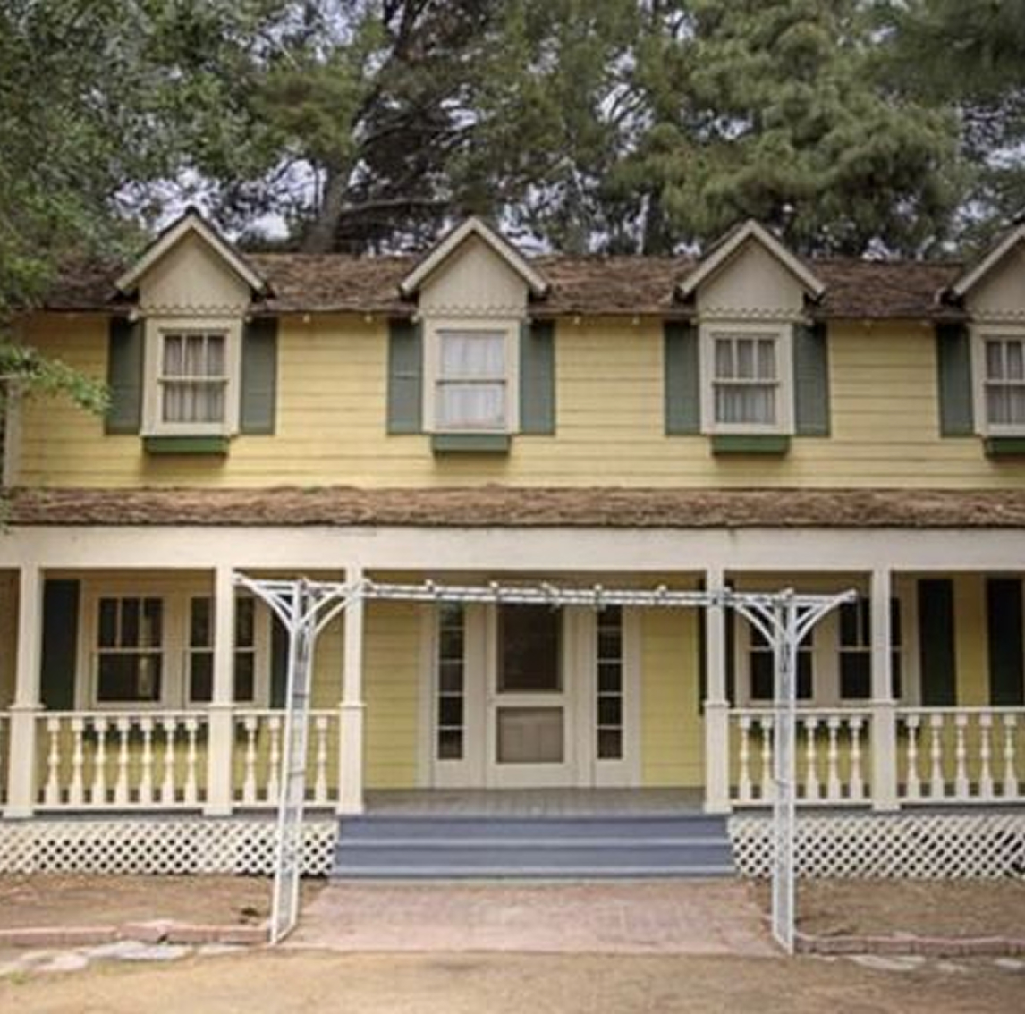 Large Yellow house with steps and a white painted porch