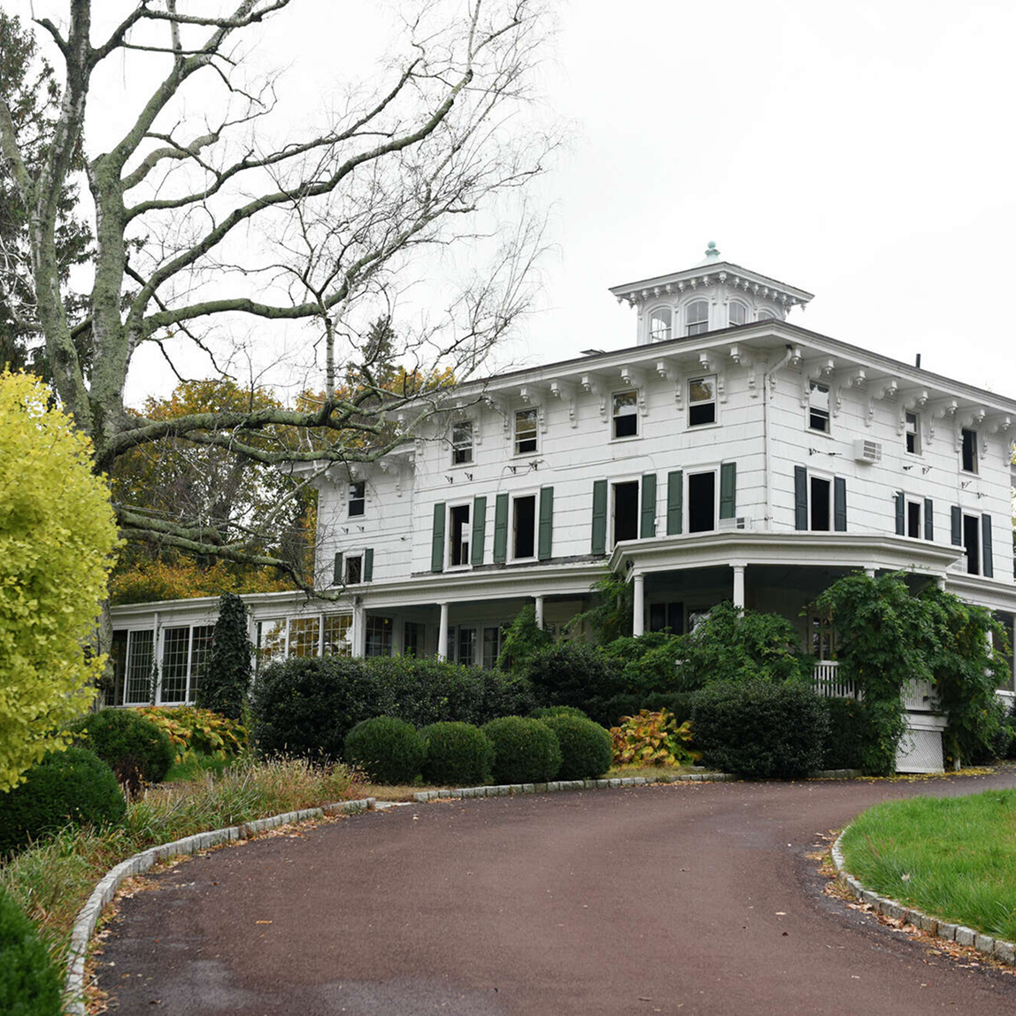 Huge white house with a long driveway up to the front door